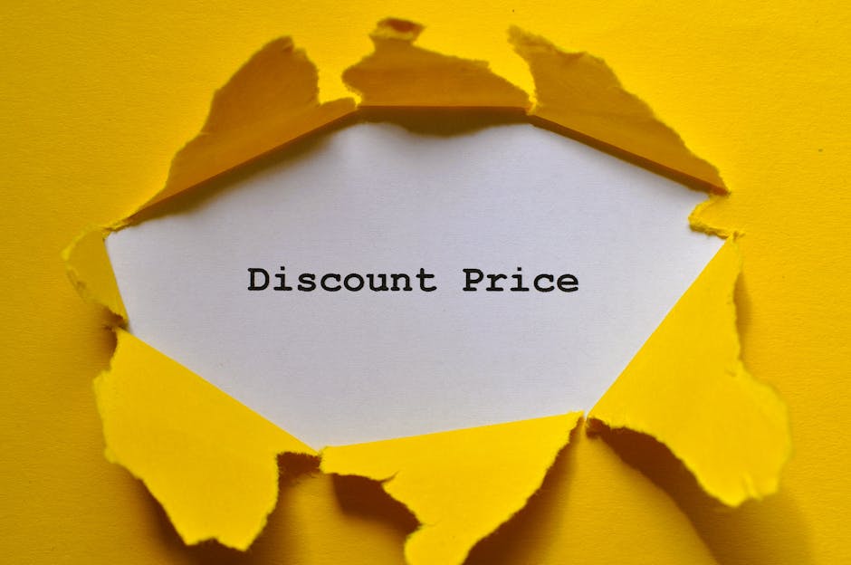 A close-up photograph of a torn yellow paper sheet with jagged edges, revealing a white piece of paper underneath that displays the text 'Discount Price' in black typewriter-style font. The torn edges have a rough texture, and the background is a solid, matte yellow surface. The image visually suggests a promotional or pricing theme, which can be associated with advertising discounts or special offers often seen in commercial signage or promotional materials related to waste disposal services. The overall scene is professionally lit with soft shadows around the torn paper edges, emphasizing the layered effect and creating a clear focus on the message.